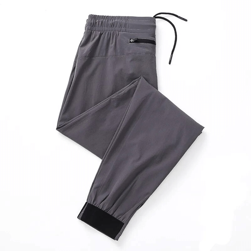 Gray Sports Quick-Drying Men's Pants with Zippered Pockets, elastic waist; perfect for running and workouts. Durable and breathable fabric.